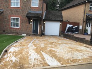 A before photo of a driveway leading to a front door and a garage in Sunbury-on-Thames