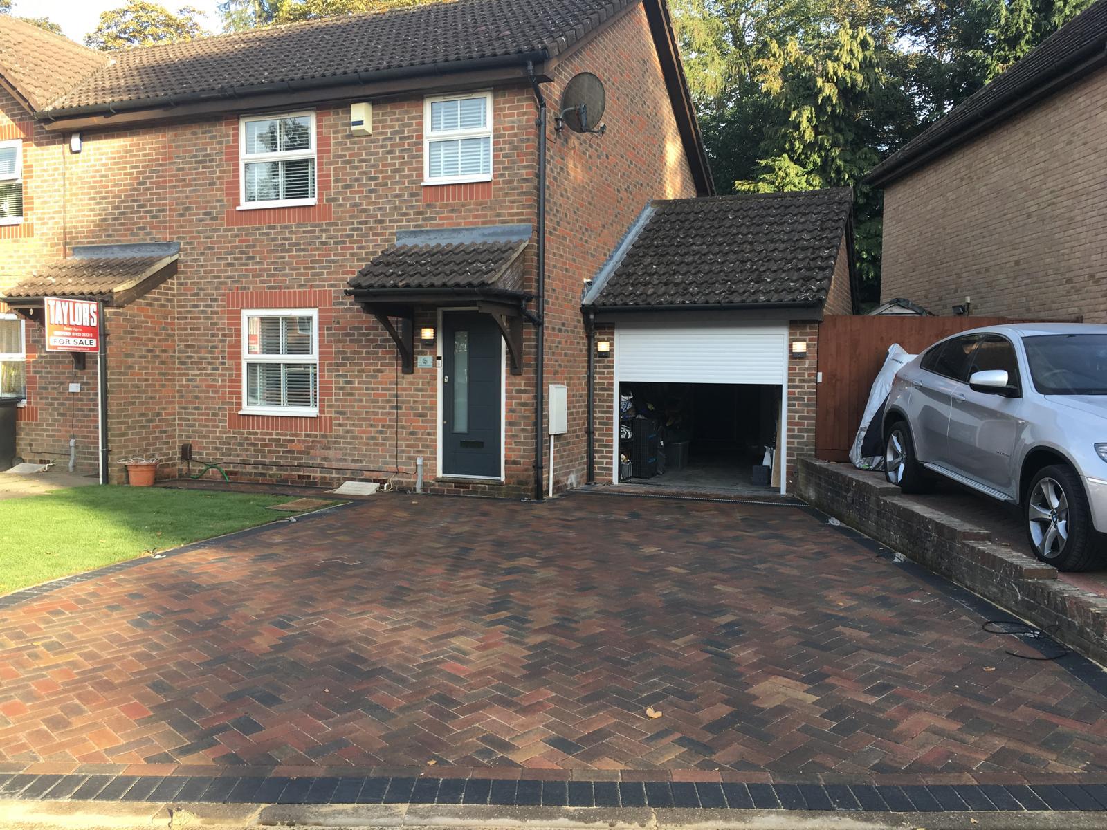 A after photo of a wide paved driveway leading to a front door and a garage in Sunbury-on-Thames